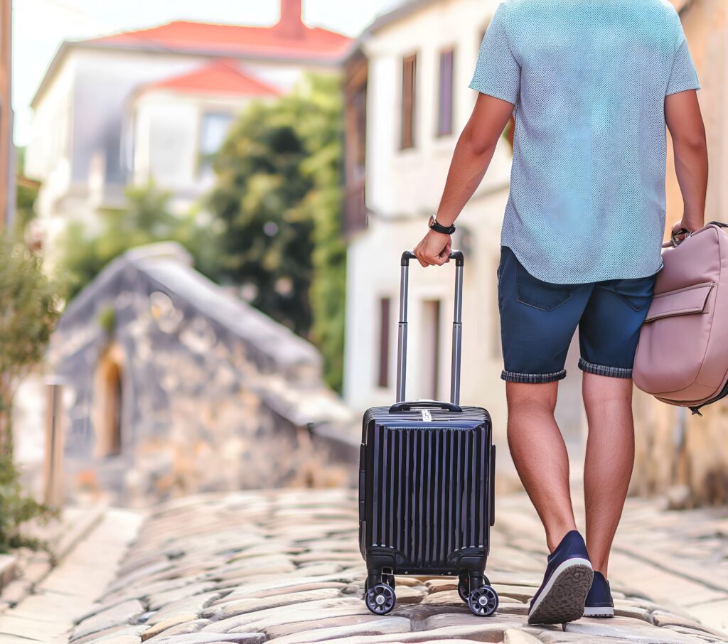 10 Hot Tips for Proper Travel Preparation by WebTaxi 6 traveler walking down cobblestone street pulling suitcase them